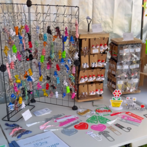 Animal keyrings, earrings and personalised 3D-printed products arranged on a table