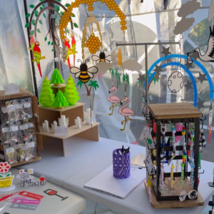 Cot mobile hanging above the stall, showing colourful 3D-printed pieces
