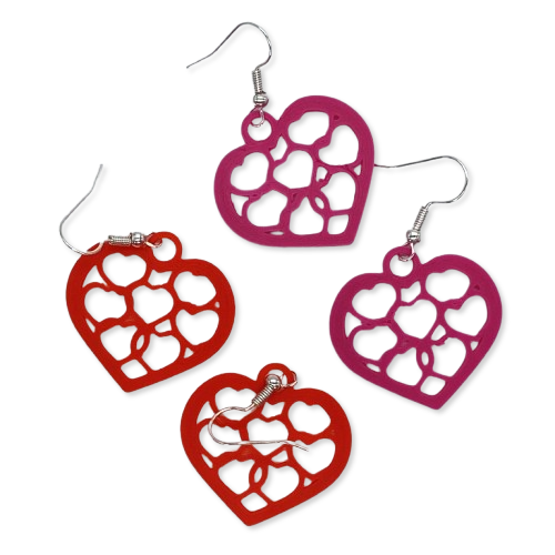 Two pairs of heart-shaped earrings with cut-out designs, one pair red and one pair purple, on a white background. Two pairs of heart-shaped earrings with cut-out designs, one pair red and one pair purple, on a white background.